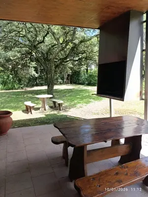 a wooden bench with a flat screen tv on a patio at Cabañas Viena II cerquita de Villa General Belgrano in Villa Ciudad Parque
