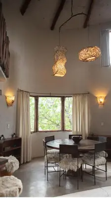a dining room with a table and chairs and windows at Cabañas Bendita Tierra 1 in Los Molles
