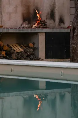 a fire grill with a pile of wood and fire ashes at Casita Champaqui in Villa de Las Rosas