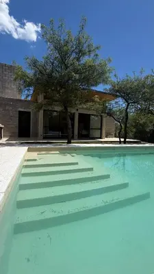 a swimming pool with steps in front of a building at Casita Champaqui in Villa de Las Rosas