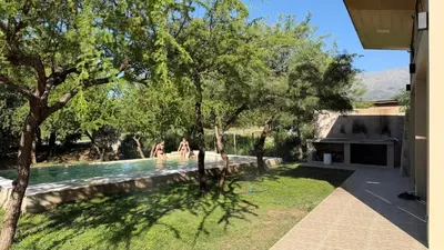 two people in the swimming pool of a house at Casita Champaqui in Villa de Las Rosas