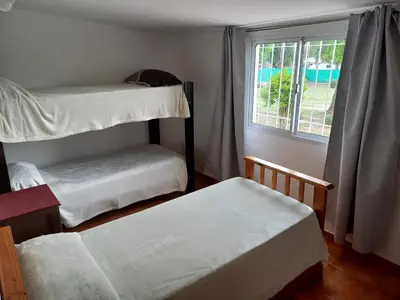 a bedroom with two bunk beds and a window at Apartamentos Las Margaritas in Villa Santa Cruz del Lago