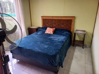 a bedroom with a bed with a blue comforter at Apartamentos Las Margaritas in Villa Santa Cruz del Lago