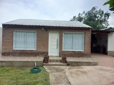 a brick house with a white door at Apartamentos Las Margaritas in Villa Santa Cruz del Lago