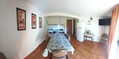 a living room with a table and a kitchen at Apartamentos Las Margaritas in Villa Santa Cruz del Lago
