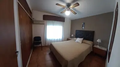 a bedroom with a bed and a ceiling fan at Apartamentos Las Margaritas in Villa Santa Cruz del Lago