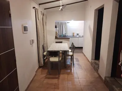 a dining room with a table and chairs and a kitchen at Las Toribias II in El Rincón