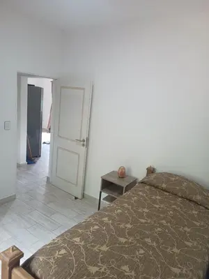a bedroom with a bed and a door and a table at Bustos-Ariza in Villa Cura Brochero