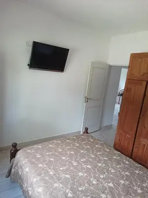 a bedroom with a bed and a flat screen tv on the wall at Bustos-Ariza in Villa Cura Brochero