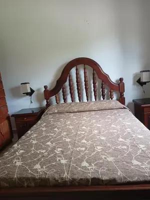 a bedroom with a bed with a wooden head board at Bustos-Ariza in Villa Cura Brochero