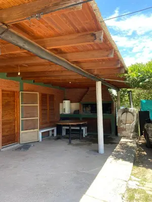 a wooden pergola with a picnic table under it at Casa Mi Sueño in Villa Cura Brochero