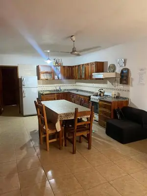 a kitchen with a table and chairs and a kitchen with a refrigerator at Casa Mi Sueño in Villa Cura Brochero