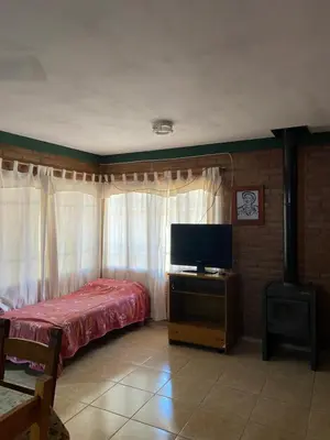 a bedroom with a bed and a flat screen tv at Casa Mi Sueño in Villa Cura Brochero