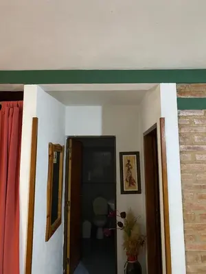 a living room with a green border on the wall at Casa Mi Sueño in Villa Cura Brochero