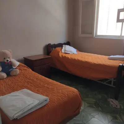 a room with two beds with a teddy bear sitting between them at Chalet Ferrari in Mina Clavero