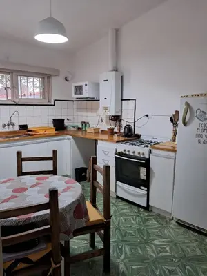 a kitchen with a table and a stove and a refrigerator at Chalet Ferrari in Mina Clavero