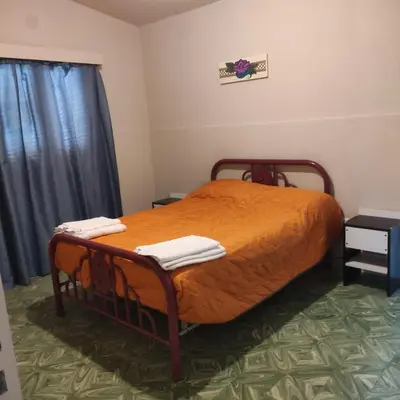 a bedroom with a bed with an orange comforter at Chalet Ferrari in Mina Clavero