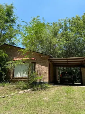 a house with a car parked in front of it at Portal del Bosque in Villa Ciudad Parque