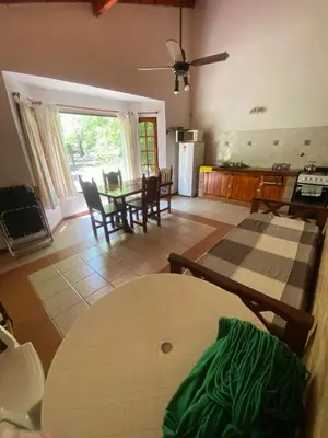 a living room with a table and a kitchen at Portal del Bosque in Villa Ciudad Parque