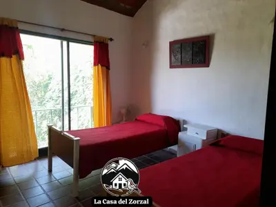 two beds in a room with a window at La Casa del Zorzal in San Antonio de Arredondo