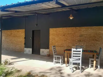 a patio with a table and chairs and a brick wall at Azul in Villa del Dique