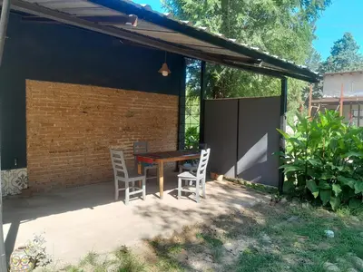 a patio with a wooden table and two chairs at Azul in Villa del Dique