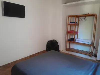 a bedroom with a bed and a tv and a shelf at Azul in Villa del Dique