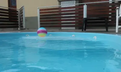 a colorful ball floating in a swimming pool at Departamentos Ecuador in Villa Carlos Paz