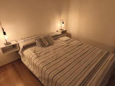 a large bed in a bedroom with two lamps at Casasdecampo pasabaxaqui in Villa Anizacate