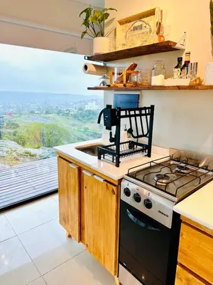 a kitchen with a stove and a sink at Surrexit Suites in Tanti
