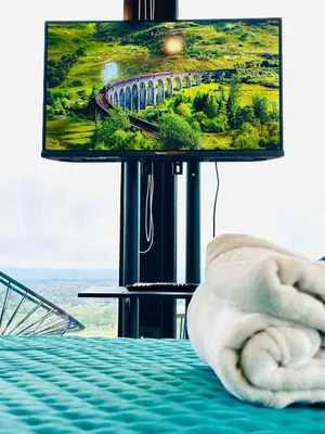 a room with a bed with a tv on a table at Surrexit Suites in Tanti