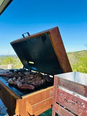 a grill with sausages and meat on it at Surrexit Suites in Tanti