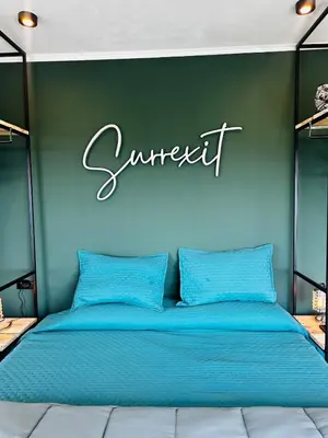 a bed in a room with a sign on the wall at Surrexit Suites in Tanti