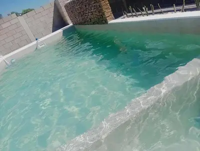 a swimming pool filled with water next to a building at Casa Francesca in Villa Carlos Paz