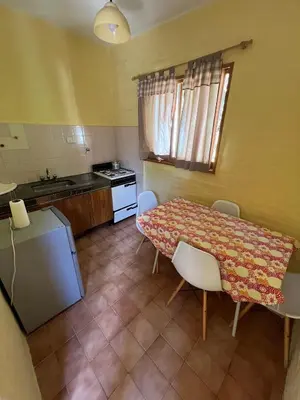 a kitchen with a table and chairs and a table and a counter at Residencial El aromo in Villa Cura Brochero