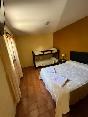 a room with two beds and a window and a bedvisor at Residencial El aromo in Villa Cura Brochero