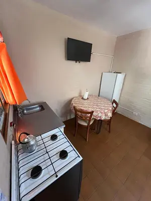 a small kitchen with a stove and a table at Residencial El aromo in Villa Cura Brochero