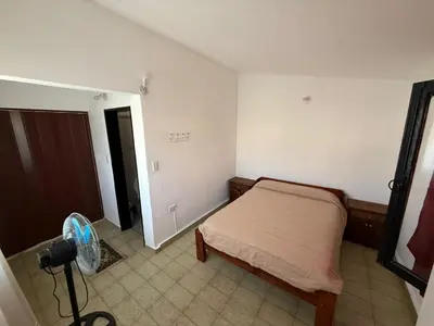 a small bedroom with a bed and a fan at Aires de familia in Villa Carlos Paz