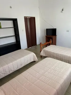 a room with two beds and a television in it at Aires de familia in Villa Carlos Paz