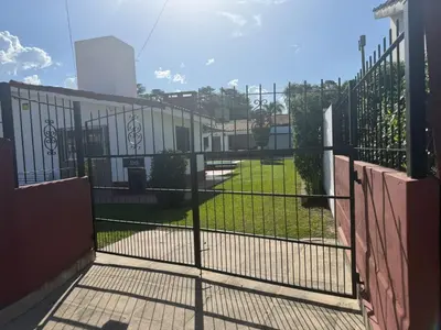 a gate in a fence with a field behind it at Aires de familia in Villa Carlos Paz