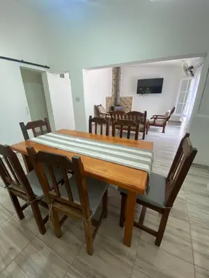 a dining room with a wooden table and chairs at Casa Familiar Centrica Abdulle in Villa Cura Brochero