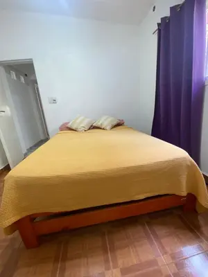 a bedroom with a bed with a yellow blanket on it at Casa Familiar Centrica Abdulle in Villa Cura Brochero
