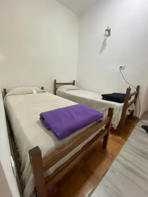two beds in a room with purple sheets at Casa Familiar Centrica Abdulle in Villa Cura Brochero