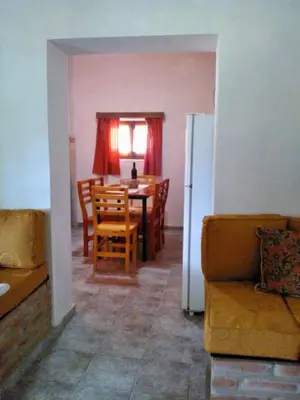 a kitchen and dining room with a table and chairs at Cabañas Quinta El Tesoro in Villa Dolores