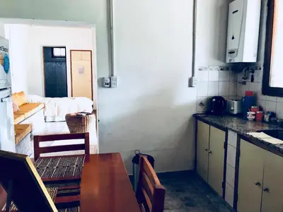 a kitchen with a table and a counter top at Cabañas Quinta El Tesoro in Villa Dolores