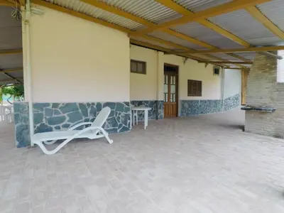 a white chair sitting on the side of a building at Cabañas Quinta El Tesoro in Villa Dolores