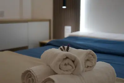 a white towel with a crown on top of a bed at Apart Lunge in Cordoba