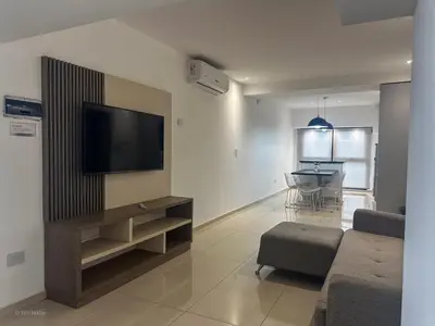 a living room with a flat screen tv on a wall at Apart Lunge in Cordoba