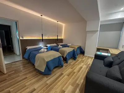 a room with three beds and a couch at Apart Lunge in Cordoba