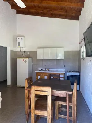 a kitchen with a table and chairs and a refrigerator at Casa Paz in Santa Rosa de Calamuchita